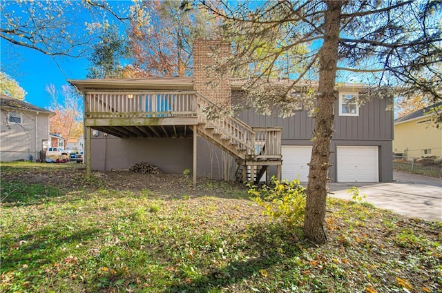 rear view of property featuring a garage and a wooden deck