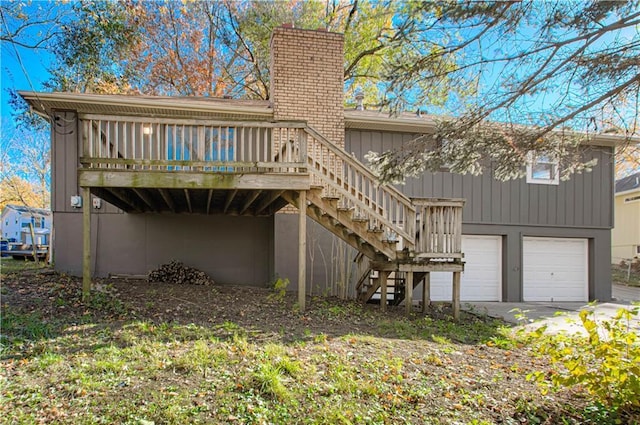 rear view of house with a garage and a wooden deck