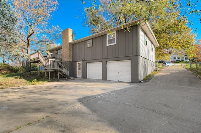 view of property exterior featuring a garage and a deck