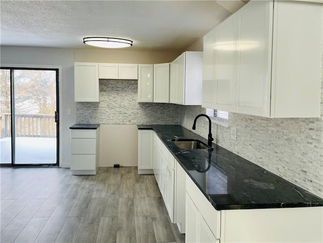 kitchen with decorative backsplash, sink, and white cabinets