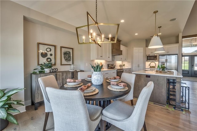 dining area with recessed lighting, a notable chandelier, baseboards, french doors, and light wood-type flooring