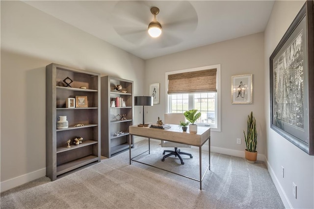 home office featuring light carpet, baseboards, and a ceiling fan