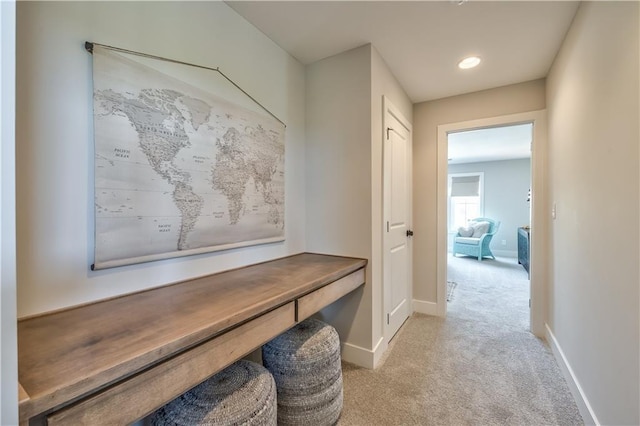 mudroom featuring baseboards and light colored carpet