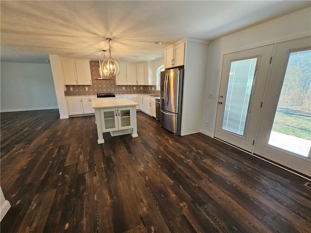 kitchen with decorative light fixtures, a center island, a wealth of natural light, and appliances with stainless steel finishes