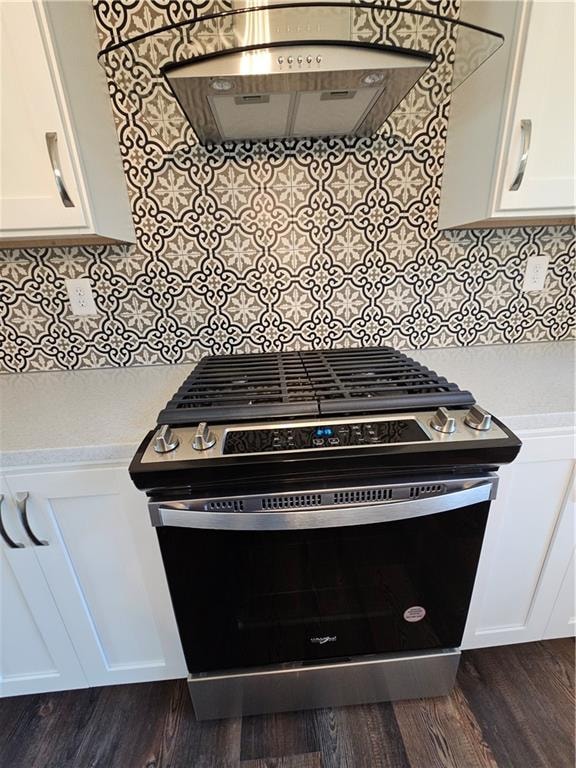 details with stainless steel gas range oven, white cabinetry, hardwood / wood-style flooring, and ventilation hood