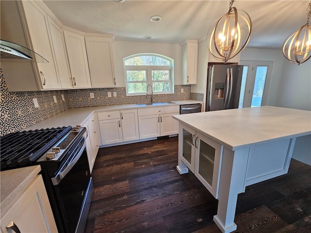 kitchen with white cabinets, pendant lighting, stainless steel appliances, and dark wood-type flooring