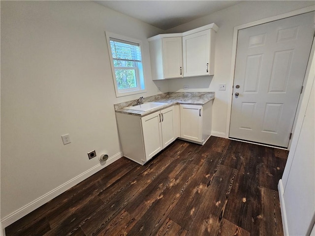 laundry room with cabinets, dark wood-type flooring, and sink