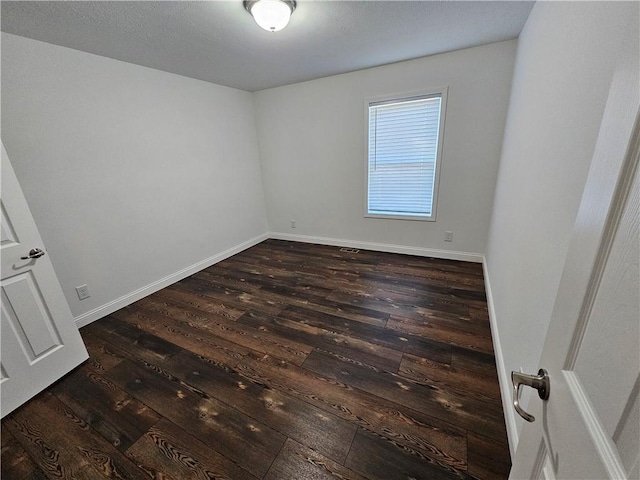 empty room with dark wood-type flooring