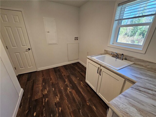 washroom featuring cabinets, dark wood-type flooring, electric panel, sink, and hookup for a washing machine