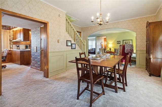 dining space featuring light colored carpet and crown molding