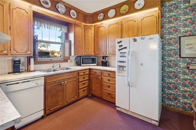 kitchen with sink, dark carpet, and white appliances