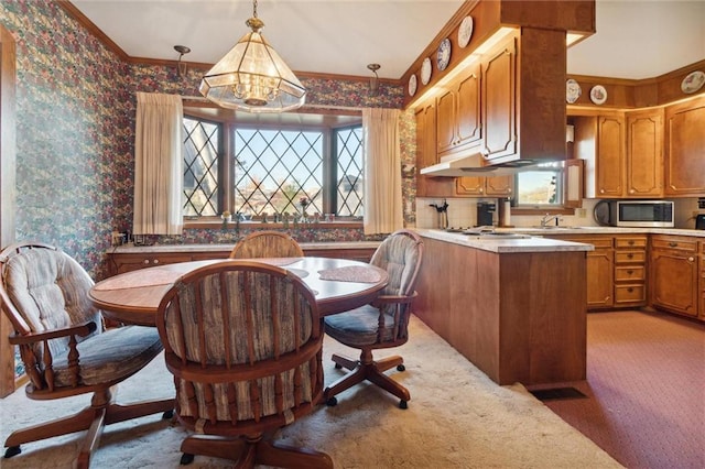 dining space featuring carpet flooring, a chandelier, a healthy amount of sunlight, and ornamental molding