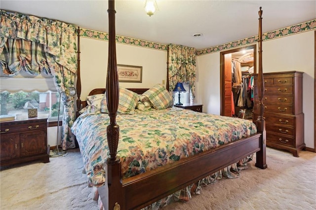 carpeted bedroom with a walk in closet and a closet