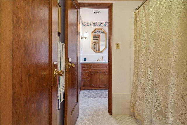 hallway featuring sink and light tile patterned floors