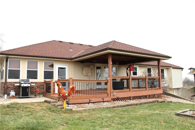 rear view of property featuring a deck and a yard