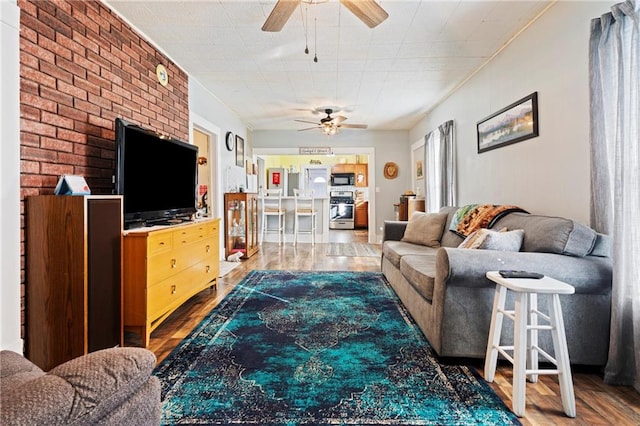 living room featuring brick wall and hardwood / wood-style flooring