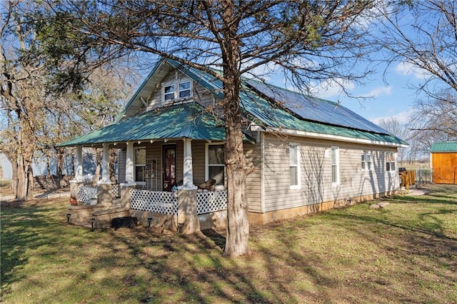 view of front of property with solar panels, a porch, and a front lawn