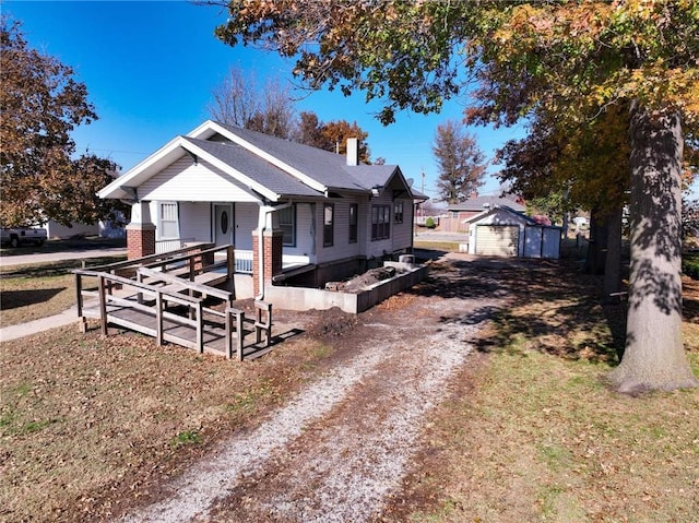 bungalow-style home with a garage and an outbuilding