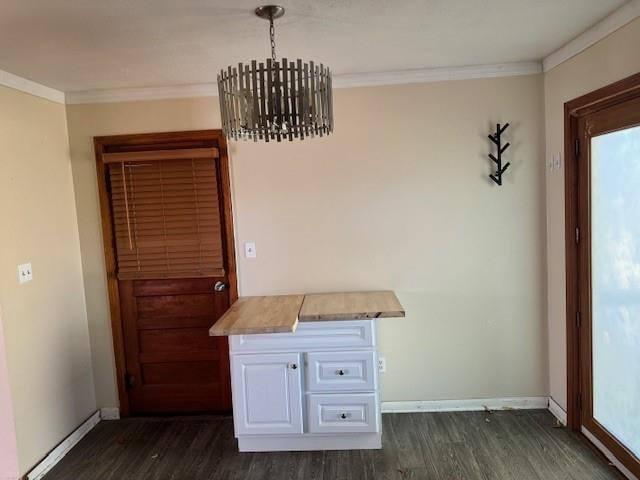 unfurnished dining area featuring dark hardwood / wood-style flooring, an inviting chandelier, and ornamental molding