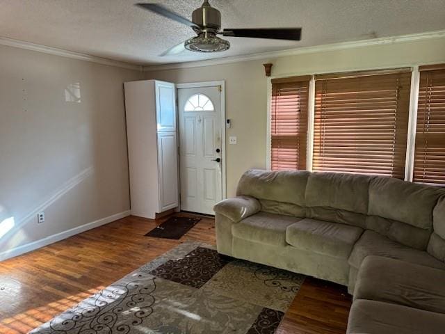 unfurnished living room featuring a textured ceiling, crown molding, ceiling fan, and dark wood-type flooring