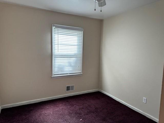 unfurnished room featuring dark colored carpet and ceiling fan