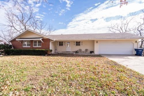 ranch-style house with a garage and a front lawn