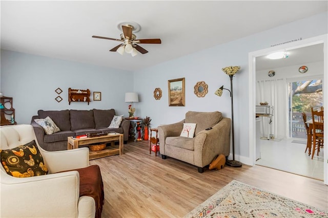 living room featuring ceiling fan and light hardwood / wood-style flooring