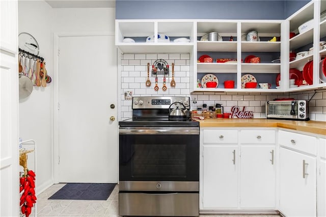 kitchen with decorative backsplash, light tile patterned floors, white cabinets, and stainless steel electric stove