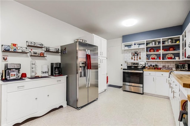 kitchen with white cabinets, decorative backsplash, and stainless steel appliances