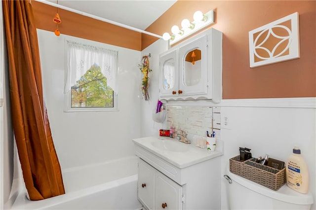 full bathroom with vanity, shower / bath combo, toilet, and backsplash