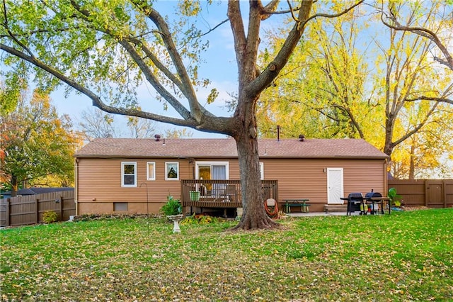 back of property with a yard and a wooden deck