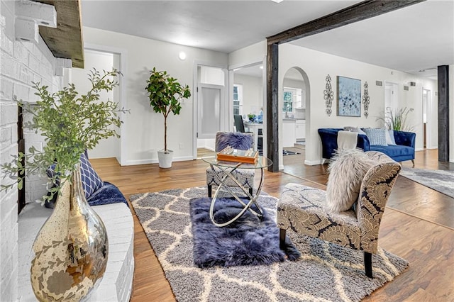 living room with beamed ceiling and wood-type flooring