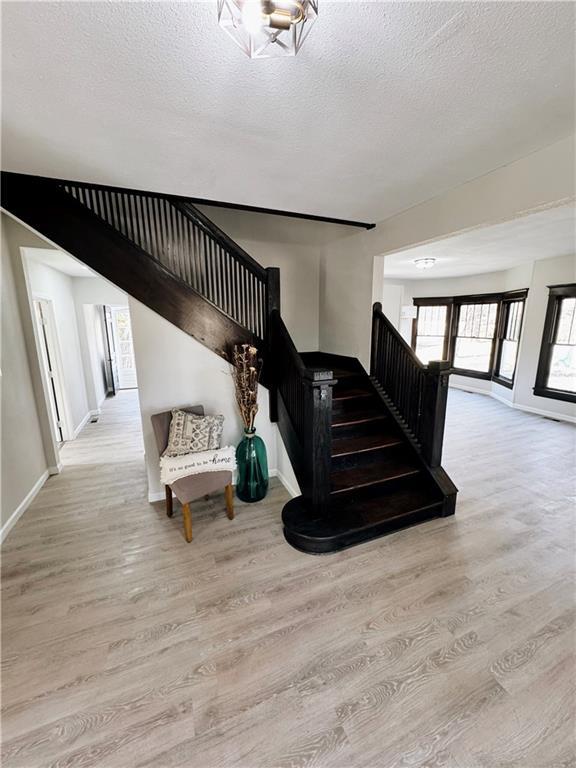 1610 S Olive St, Pittsburg, KS 66762 - stairs with wood finished floors and a textured ceiling