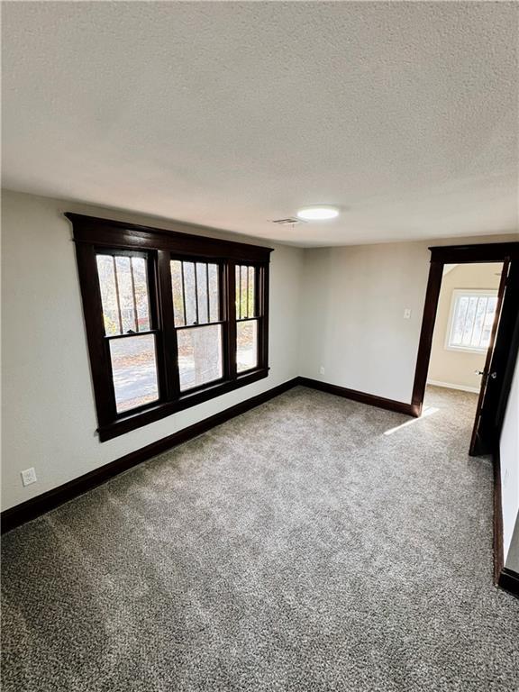 1610 S Olive St, Pittsburg, KS 66762 - carpeted spare room featuring a textured ceiling and baseboards