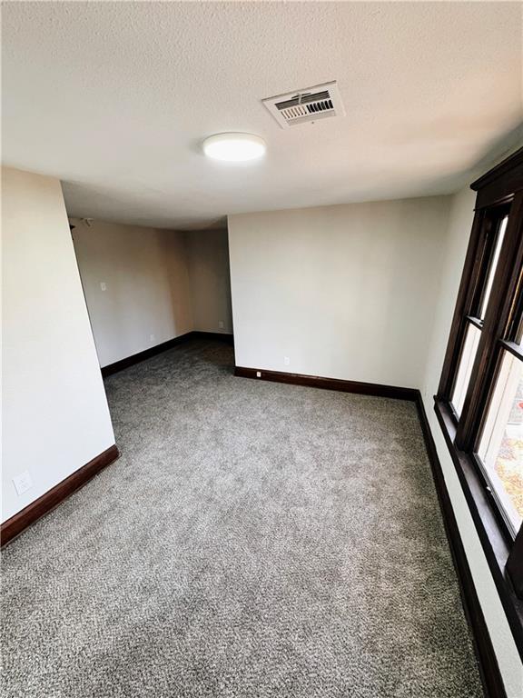 1610 S Olive St, Pittsburg, KS 66762 - empty room featuring carpet flooring and a textured ceiling