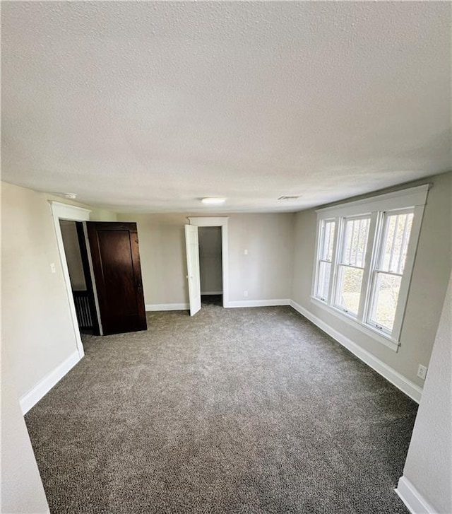 1610 S Olive St, Pittsburg, KS 66762 - unfurnished room with a textured ceiling and dark carpet