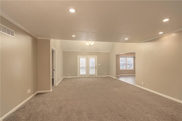 carpeted spare room featuring crown molding, plenty of natural light, and an inviting chandelier