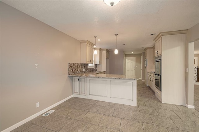 kitchen with kitchen peninsula, decorative backsplash, a textured ceiling, double oven, and pendant lighting