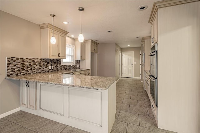 kitchen with pendant lighting, backsplash, cream cabinets, light stone countertops, and kitchen peninsula