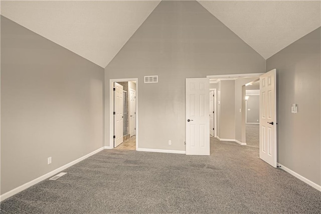 unfurnished bedroom featuring a walk in closet, high vaulted ceiling, and light colored carpet