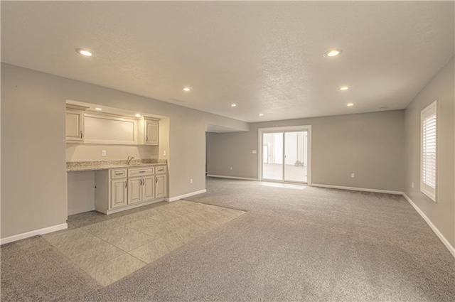 unfurnished living room featuring light carpet and a wealth of natural light