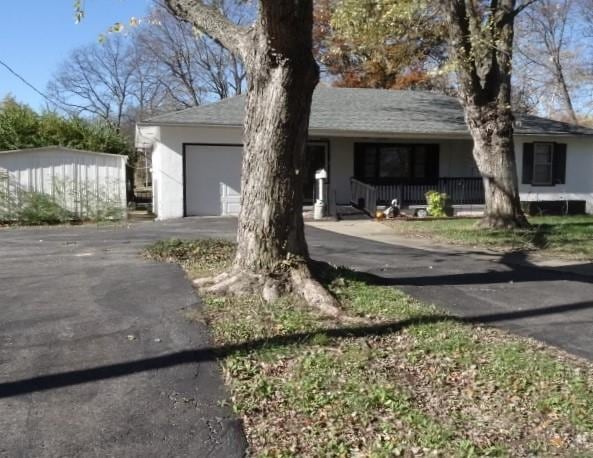 ranch-style home featuring covered porch and a garage