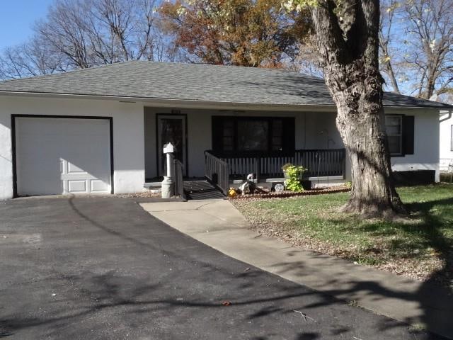 single story home featuring covered porch and a garage