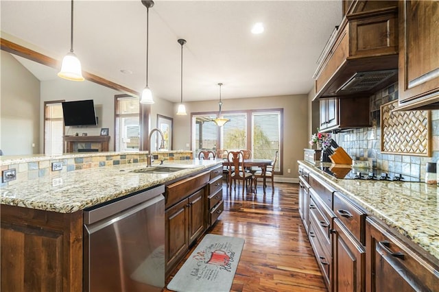 kitchen with hanging light fixtures, decorative backsplash, stainless steel dishwasher, and a spacious island