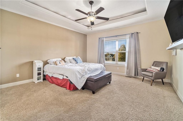 carpeted bedroom featuring a tray ceiling, ornamental molding, and ceiling fan