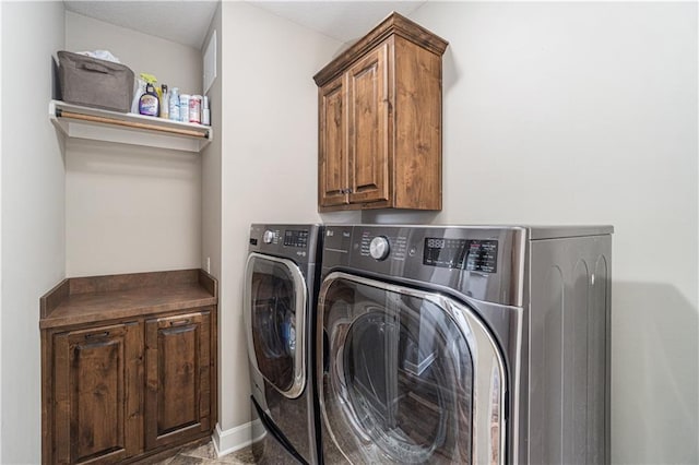 laundry area with washing machine and dryer and cabinets