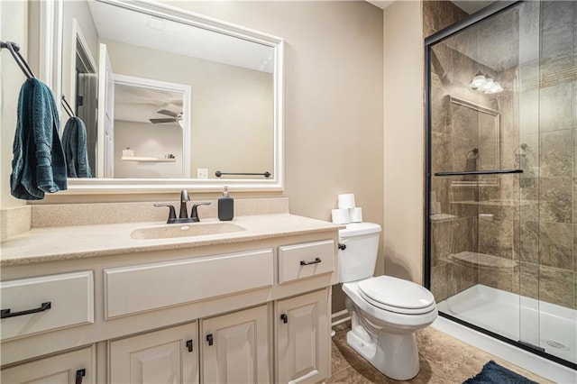 bathroom with vanity, a shower with door, and toilet