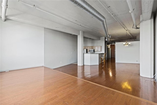 basement with hardwood / wood-style flooring and an inviting chandelier