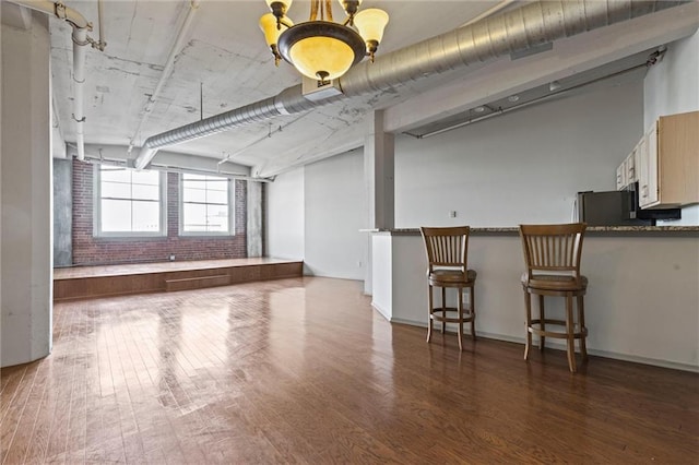 interior space with brick wall and dark hardwood / wood-style floors