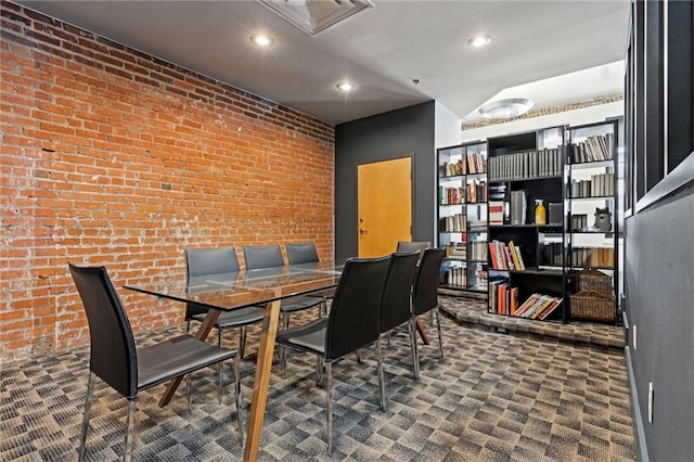 dining room with dark carpet and brick wall